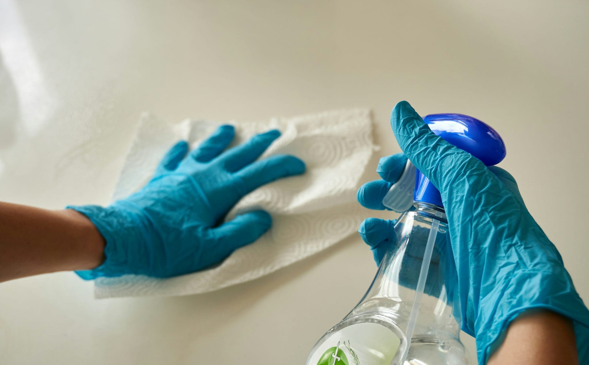 An example of commercial cleaning & janitorial services - an individual disinfecting the surface top of a table.